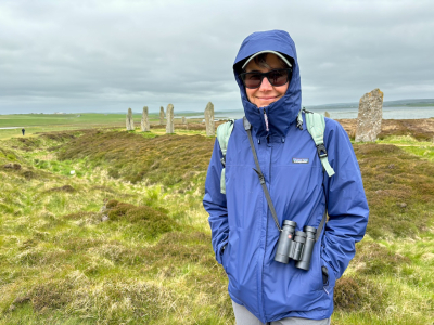 Karen at Ring of Brodgar on a cold, windy day beneath a layer of stratocumulus.